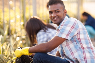 man wearing yellow rubber gloves working outside in a field
